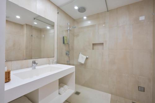 a white bathroom with a sink and a shower at Caloura Hotel Resort in Caloura