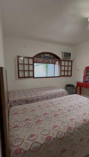 a bedroom with a bed and a window at Casa com área de lazer em Xerém in Duque de Caxias