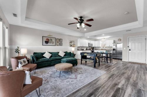 a living room with a green couch and a table at Gorgeous Resort, Fish Private Lake, Pools, Golf! in Branson West