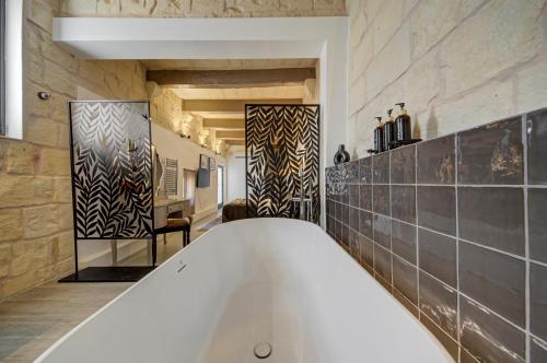 a large bath tub in a bathroom with at Zaffir Retreat in Żebbuġ
