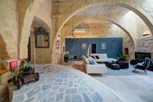 a living room with a stone wall and a living room with a couch at Zaffir Retreat in Żebbuġ