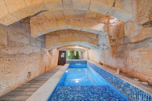 an indoor swimming pool in a stone walled building at Zaffir Retreat in Żebbuġ