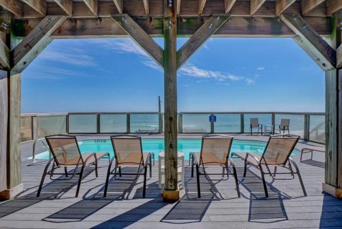a group of chairs sitting around a swimming pool at Tipsy Turtle South-bOceanfront Oasis - Dog Friendly - Pool in Surf City