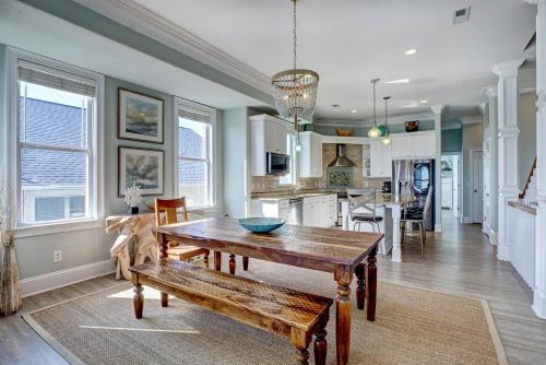 a dining room and kitchen with a wooden table and bench at Tipsy Turtle South-bOceanfront Oasis - Dog Friendly - Pool in Surf City