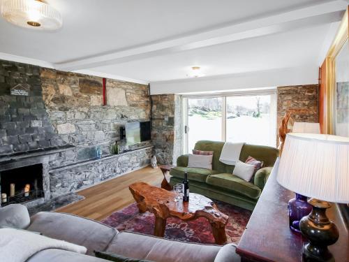 a living room with a stone wall at Coelard The Barn - Uk50538 in Appin