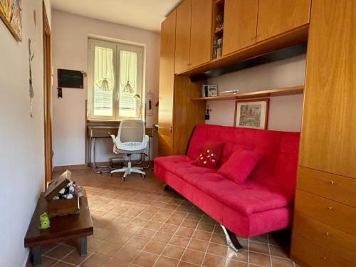 a living room with a red couch and a desk at Casa dei Gufi in Cella