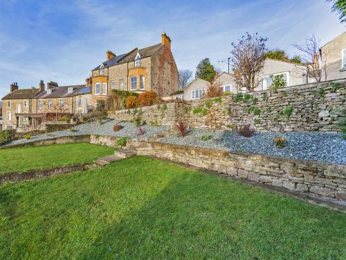 a stone retaining wall in front of a yard at Frenchgate Cottage in Richmond