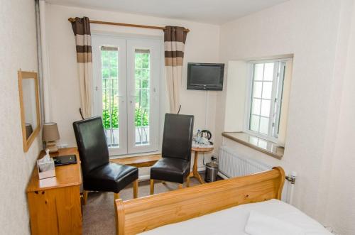 a bedroom with two chairs and a desk and a bed at Royal Lodge in Symonds Yat