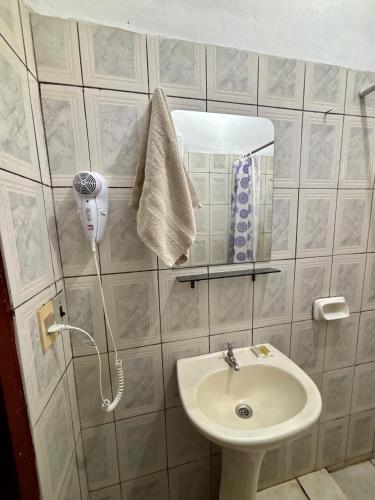 a bathroom with a sink and a phone on a wall at Confort total, cerca de todo in Asunción