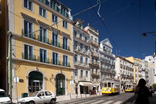a city street with buildings and a yellow tram at LSA Ascensor da Bica by Numa in Lisbon