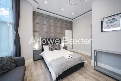 a bedroom with a bed and a couch at Hackney Suites - En-suite rooms & amenities in London