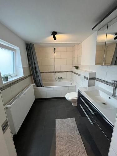 a bathroom with a tub and a toilet and a sink at Work & Stay - Monteurzimmer - FeWo am NOK in Rendsburg