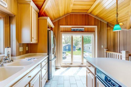 a kitchen with wooden ceilings and a large window at The Boat House w/ Dock: Enjoy Lake Life! in North Webster