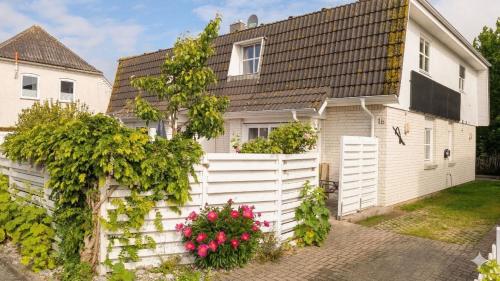 a white house with a fence and flowers at am-hoeben in Fehmarn