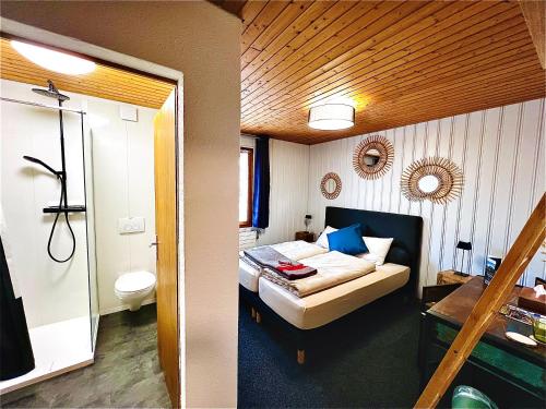 a small bedroom with a bed and a bathroom at Hôtel Restaurant Les Cernets, "Val-de-Travers" in Les Verrières