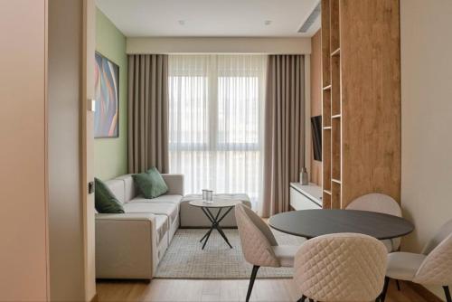 a living room with a couch and a table at STYLO Residences & Suites in Tashkent