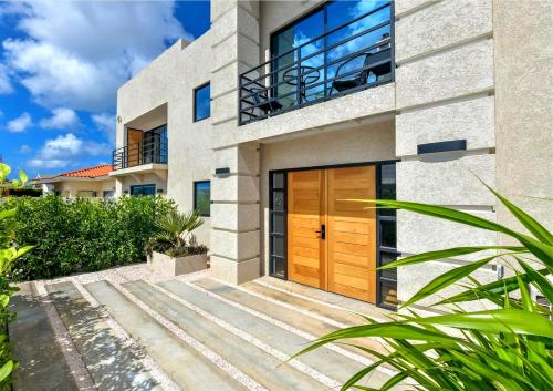 a house with a wooden door and a balcony at Aruba Islander Residence com in Oranjestad