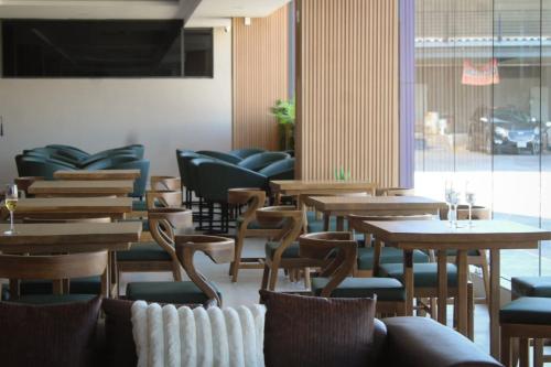 a restaurant with wooden tables and chairs and a window at Hotel JVD Inn - Tonalá Centro GDL in Guadalajara