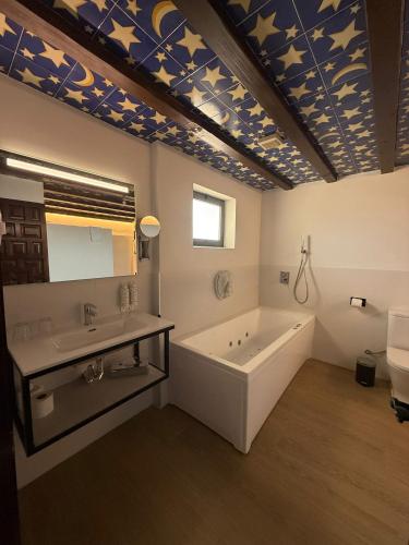 a bathroom with a tub and a sink and a mirror at Hotel Castillo de Monda in Monda