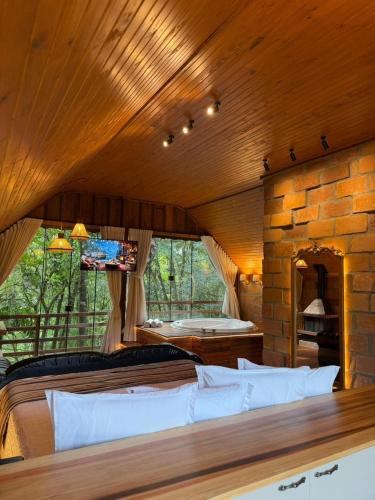 a room with a large bed and a stone wall at Chalé Belluno in Casca