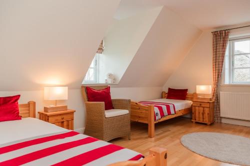 a attic bedroom with two beds and a chair at Lunhues Lucia in Dunsum