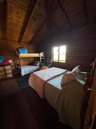 a bedroom with two beds and a window at Cabañas - Raíces de la Sierra in Balcarce