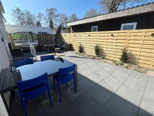 a patio with a table and chairs and a fence at Veluwse Vlucht in Putten