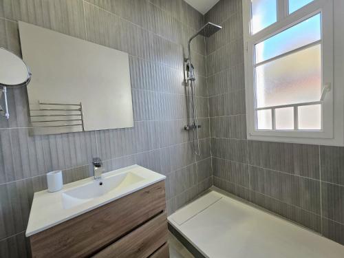 a bathroom with a sink and a mirror and a window at L'Authentique Centre-Ville - Perpignan in Perpignan