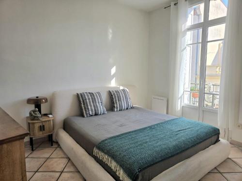 a bedroom with a bed in a room with a window at L'Authentique Centre-Ville - Perpignan in Perpignan