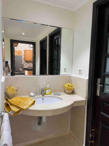 a bathroom with a sink and a large mirror at Azul Blue House in Sidi Bouzid