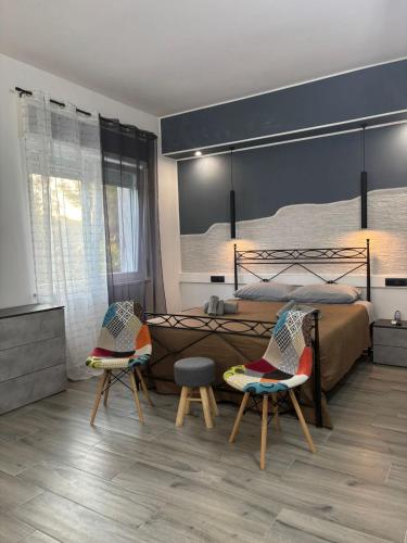 a bedroom with a large bed and two chairs at La Fenice 40 in Numana