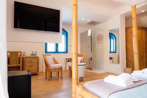 a room with two beds and a flat screen tv at Didimos Resort in Reggio di Calabria