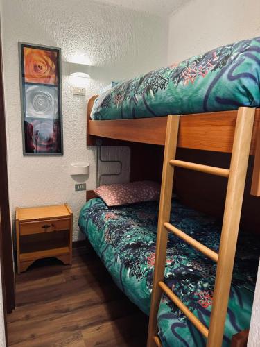 a room with two bunk beds and a night stand at Montecampione Prati B in Pian Camuno