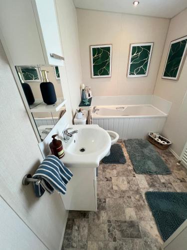 a bathroom with a sink and a tub and a toilet at Celebration by the sea in Redcar