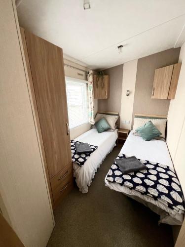 a small room with two beds and a window at Celebration by the sea in Redcar