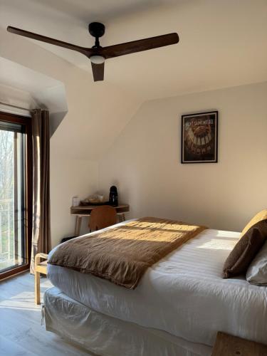 a bedroom with a bed and a ceiling fan at L'Orée du Mont proche du mont saint Michel in Pontorson