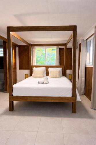 a large bed with a wooden frame in a room at Zabitant Lodge Éliane in Vieux-Habitants
