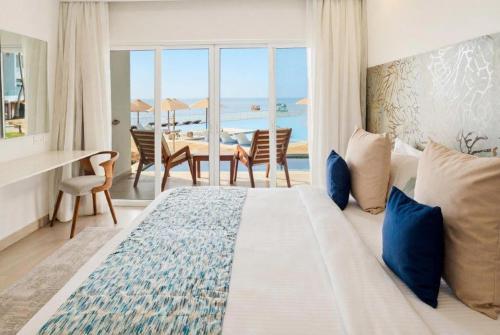 バンブリにあるBamburi Beach Hotelのベッドとテーブルがあり、海が見える寝室