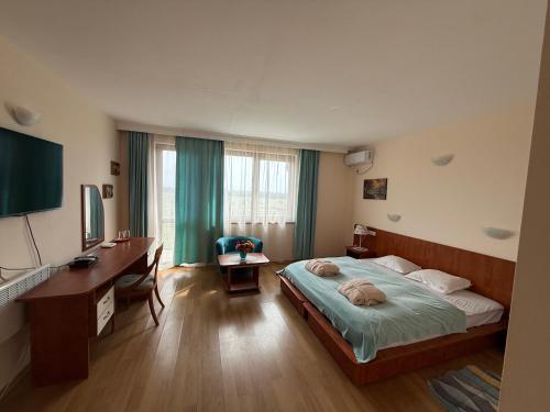 a hotel room with a bed and a desk and a desk at Златна люспа in Bŭlgarevo