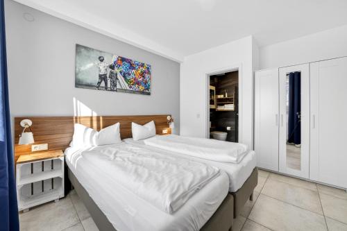 a bedroom with a large bed and a picture on the wall at JUNIPRO Apartments Bostalsee in Bosen-Eckelhausen