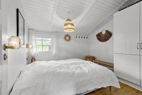 a white bedroom with a large bed and a window at FAN026-Fano-Hedesvinget-12 in Fanø