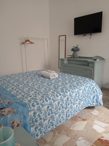 a bedroom with a bed and a dresser with a television at Maison d'Artiste Siracusa Belvedere in Belvedere