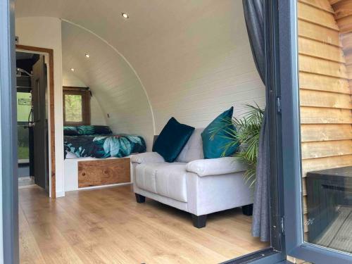 a living room with a couch and a bedroom at Glamping pod with en-suite & underfloor heating in Haverfordwest