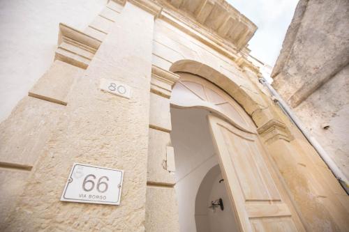 a building with a door with a sign on it at Il Borgo in Poggiardo
