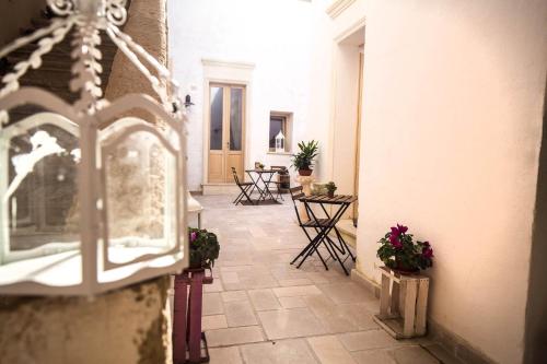 a corridor of a building with chairs and flowers at Il Borgo in Poggiardo