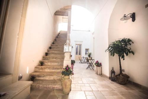 a hallway with stairs in a building with flowers at Il Borgo in Poggiardo