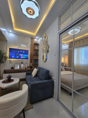 a living room with a couch and a bedroom at Kai's Luxe Balcony Suite at Royal Oceancrest Mactan in Mactan Island