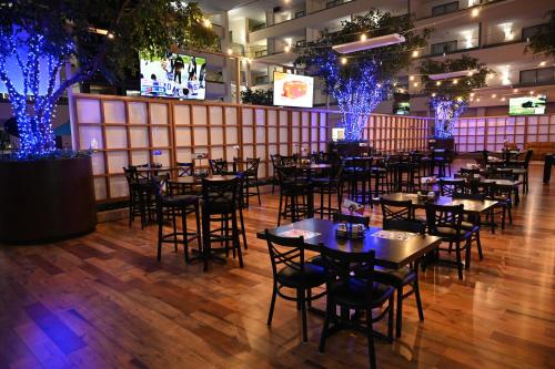 a dining room with tables and blue lights at Atrium Hotel and Suites DFW Airport in Irving