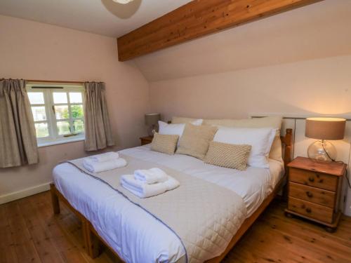 a bedroom with a bed with towels on it at Plush Cottage in Dorchester
