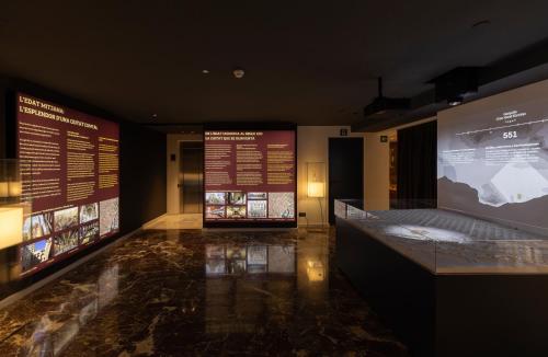 a museum with two displays of a bed and two signs at Gran Hotel Barcino 4 Sup in Barcelona